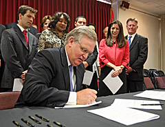 Governor Nixon signs economic development bill as legislators look on (Bill Greenblatt/UPI)