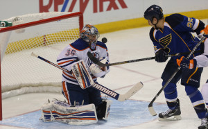 St. Louis Blues Chris Stewart (R) tries to get a stick on the puck, rolling off the body of Edmonton Oilers goaltender Nikolai Khabibulin.    UPI/Bill Greenblatt