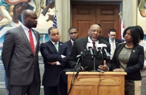 Representative Tommie Pierson (at podium) is joined by Representative Clem Smith (left) and other House Democrats who oppose the proposed transfer legislation.