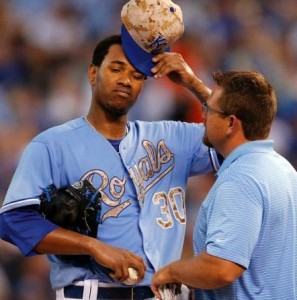 Yordano Ventura is met by a team trainer in the third inning. (photo/MLB)